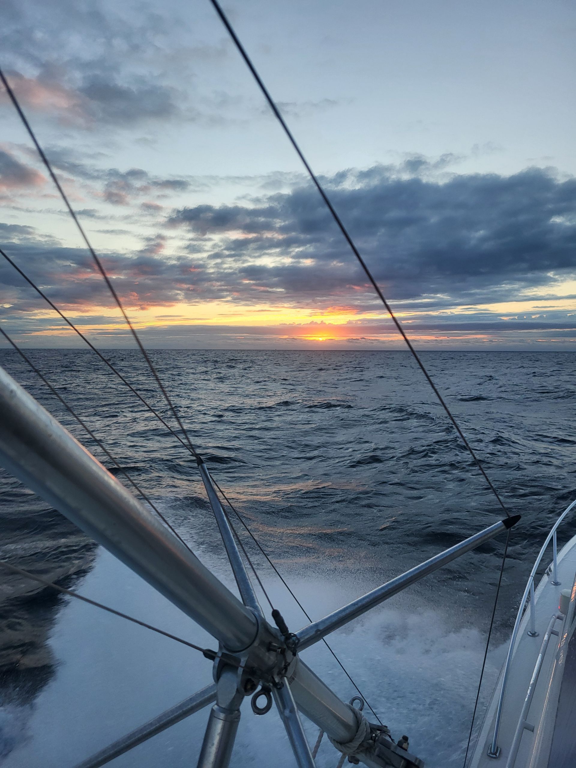 A boat in the ocean with a sunset in the background