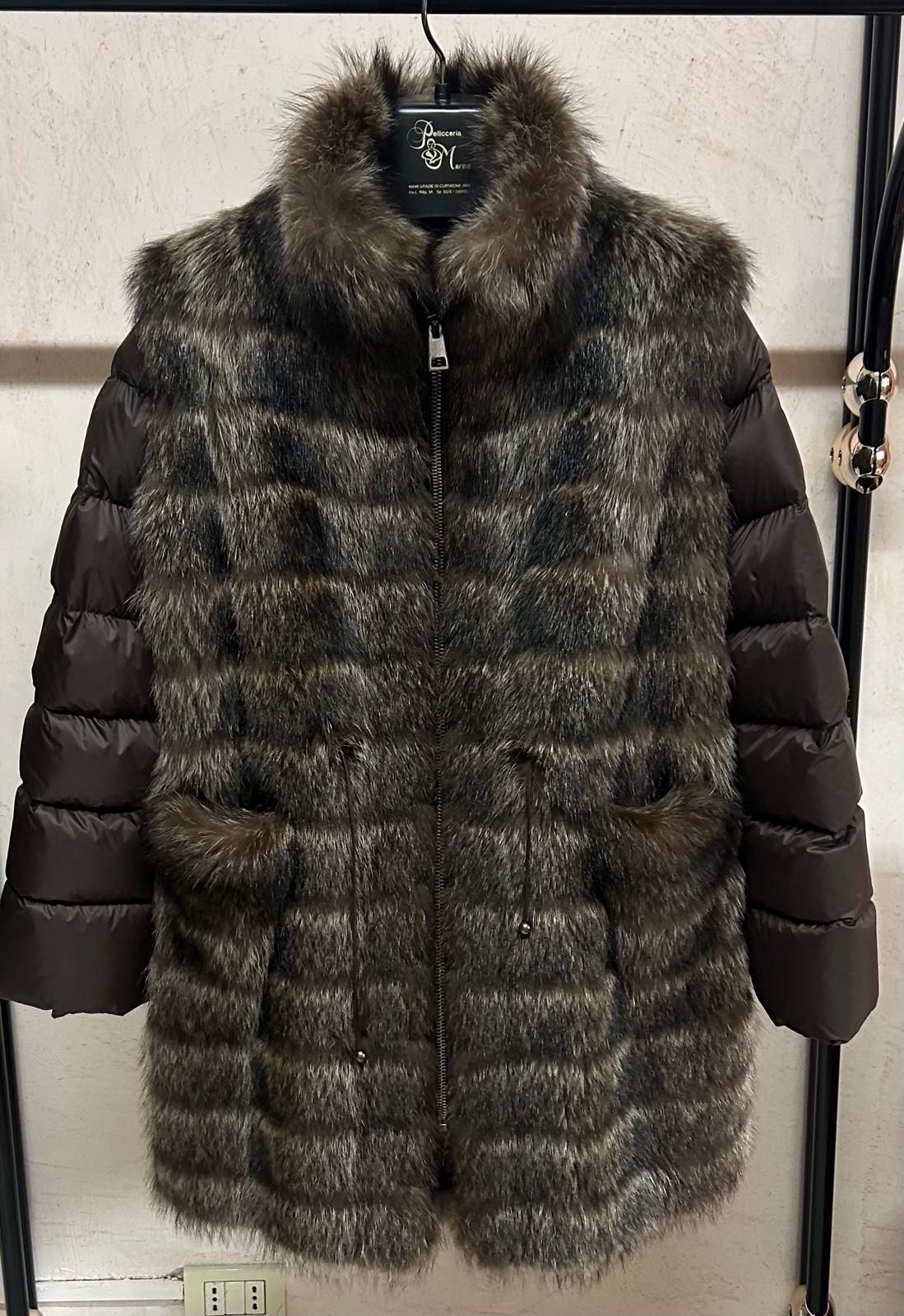 Cappotto trapuntato marrone con bordi di pelliccia e maniche scure appeso a una parete espositiva