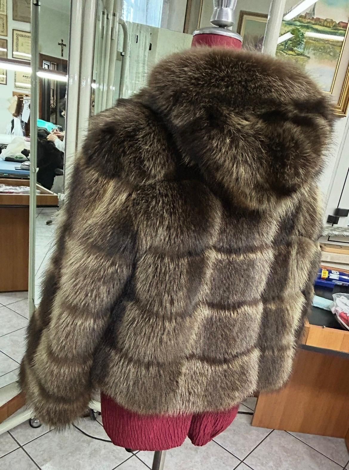Cappotto di pelliccia marrone esposto su un manichino nella vetrina di un negozio di abbigliamento.