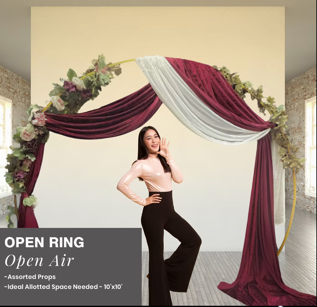 Open Air event backdrop with burgundy and white drapes, floral accents, and a standing model