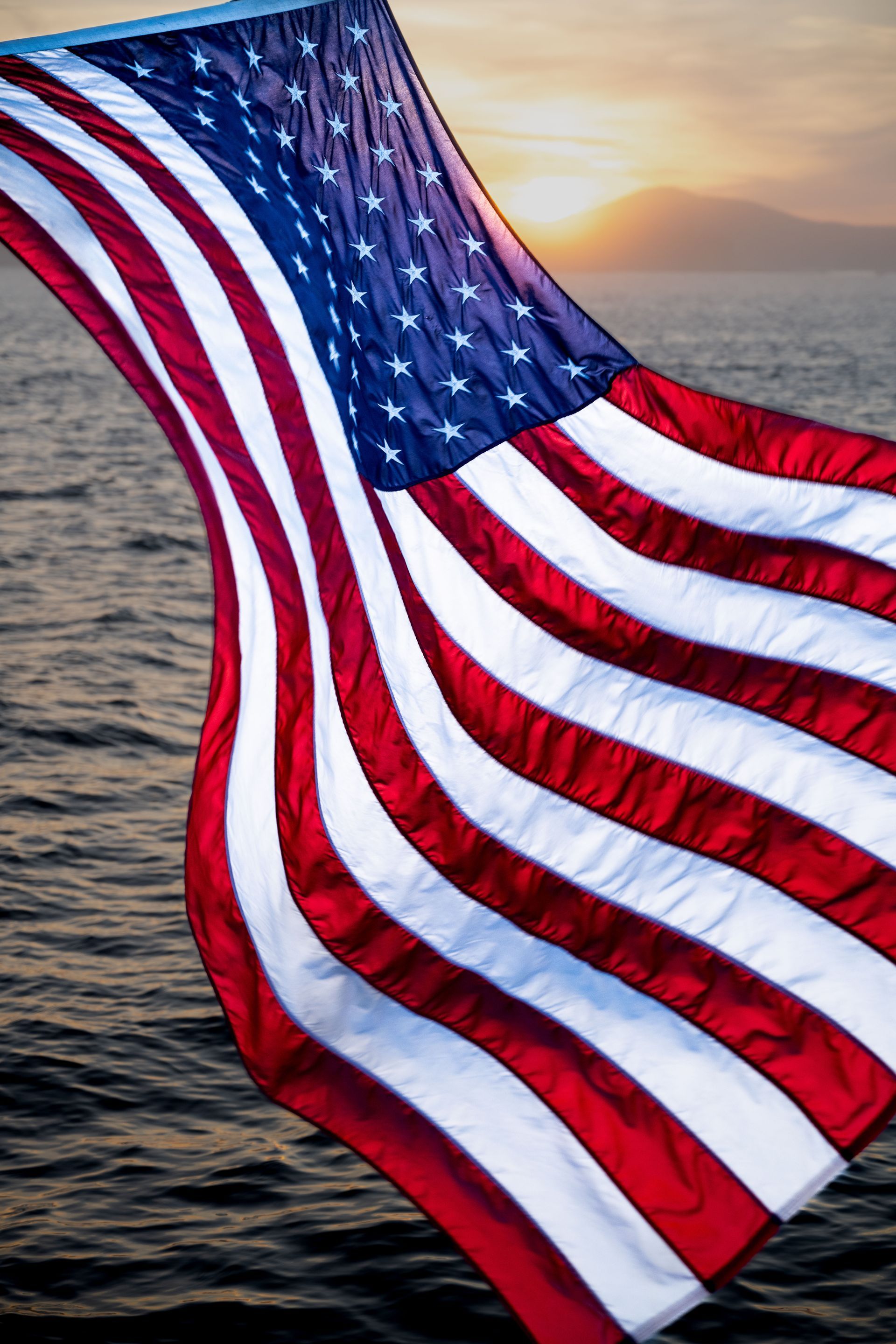 an american flag is waving in the wind over the ocean.  Brad Burgess Photography, Talking Excitingly