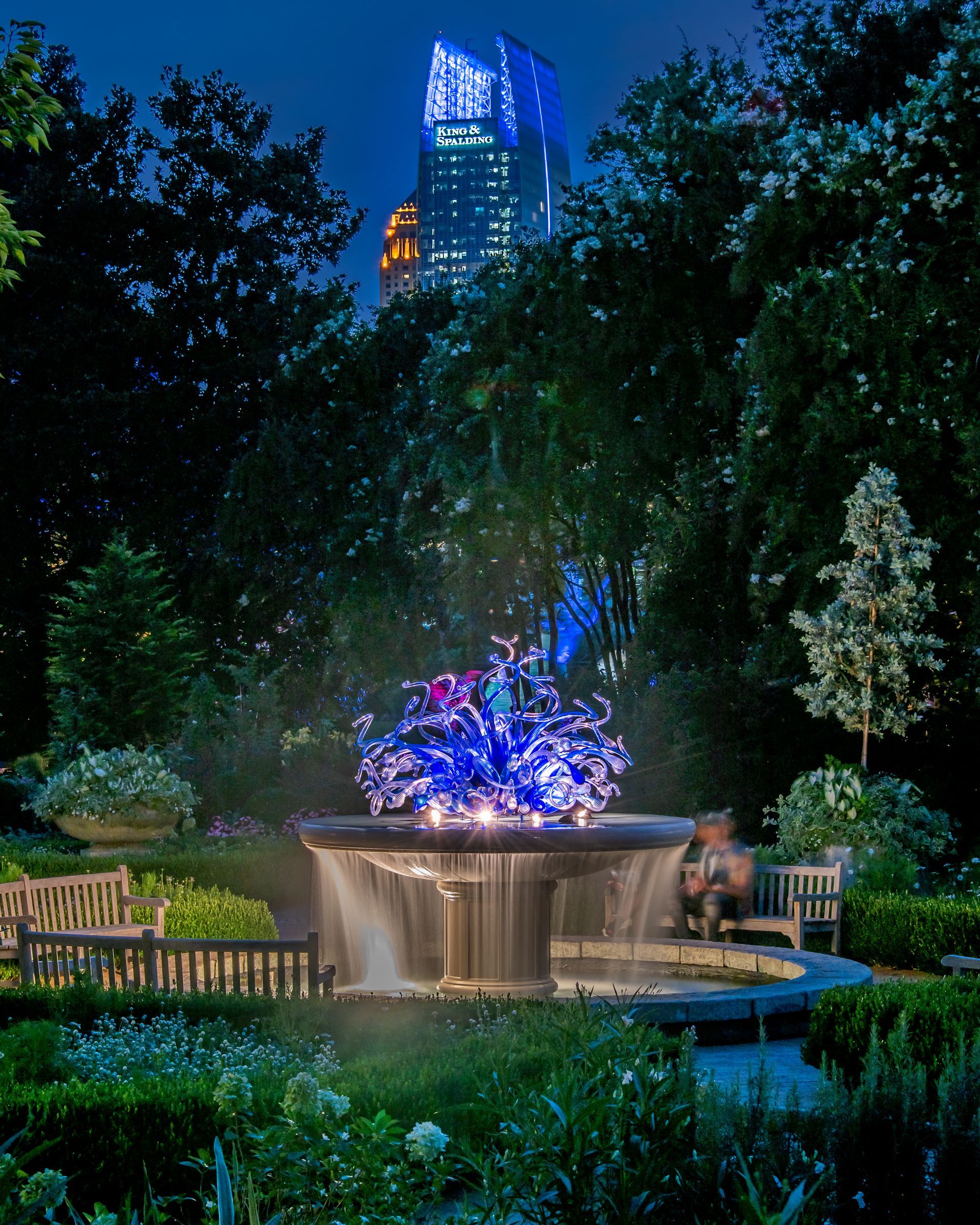 a fountain in a park with a skyscraper in the background. Atlanta Botanical Gardens, Brad Burgess Photography, Talking Excitingly