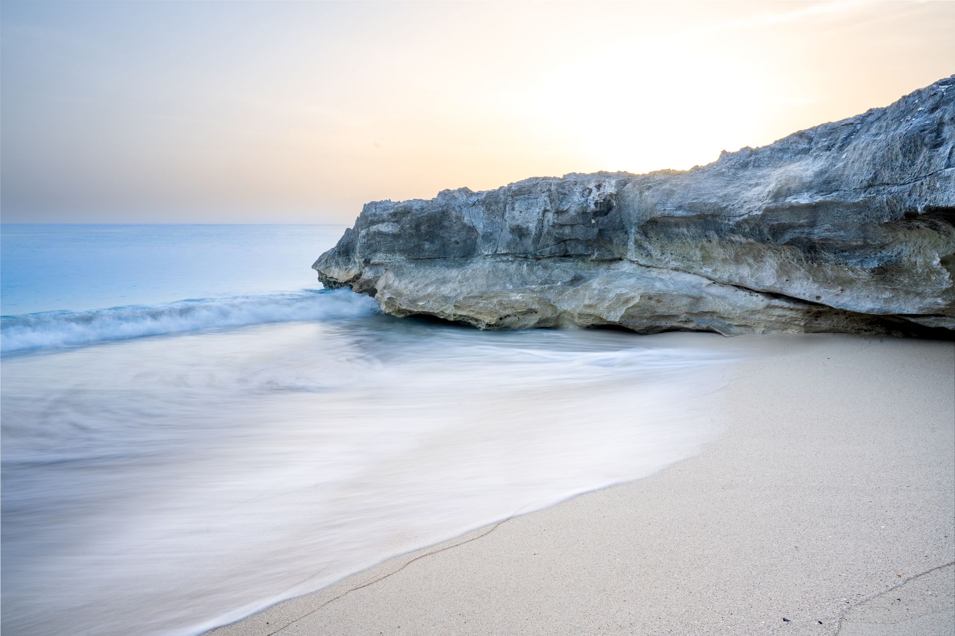 a long exposure of a beach with a rocky cliff in the background. Talking Excitingly, Brad Burgess Photography