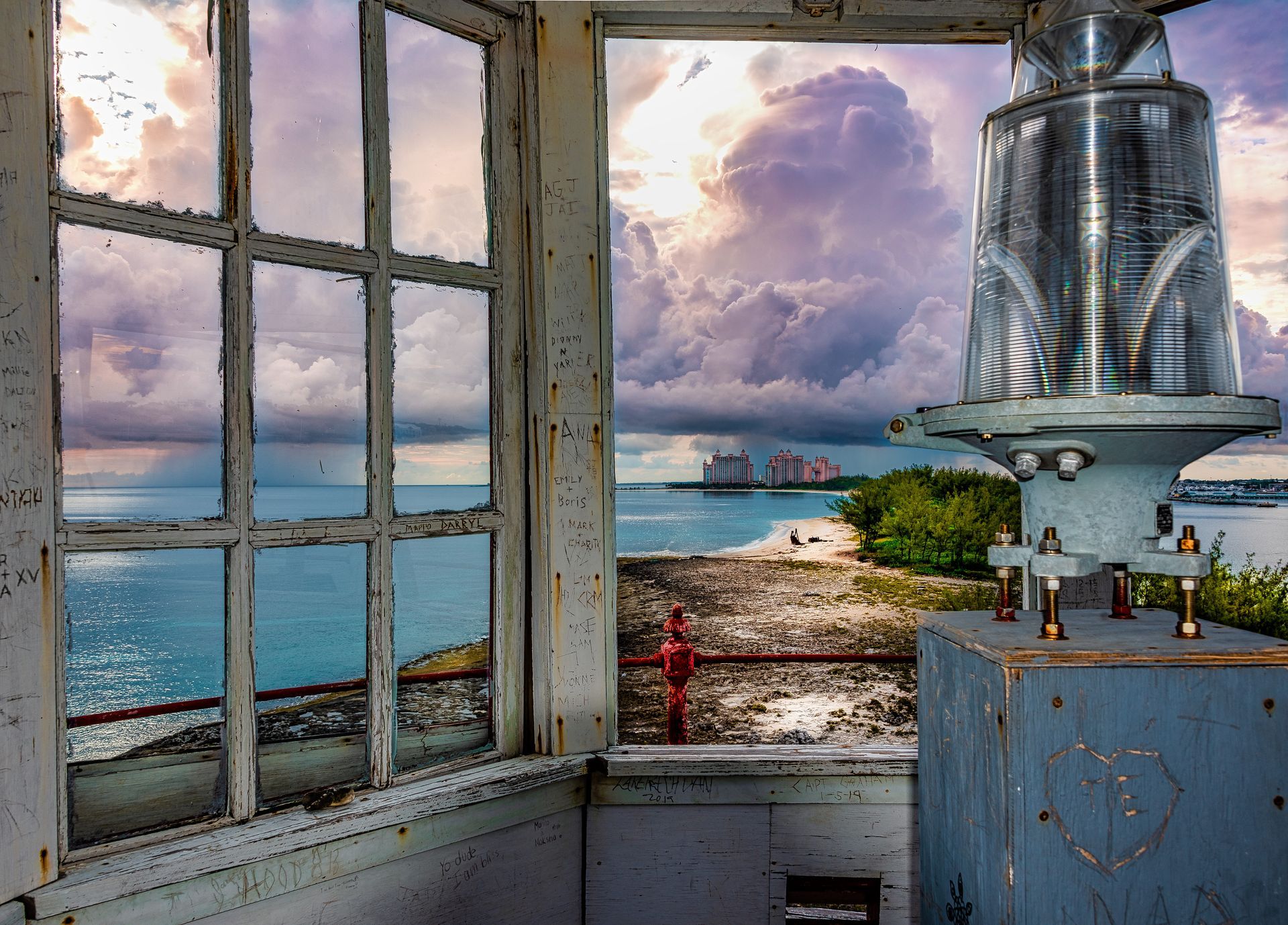 a view of the ocean through a lighthouse window with the Atlantis Resort in the background. Nassau Harbour Lighthouse, Talking Excitingly, Brad Burgess Photography