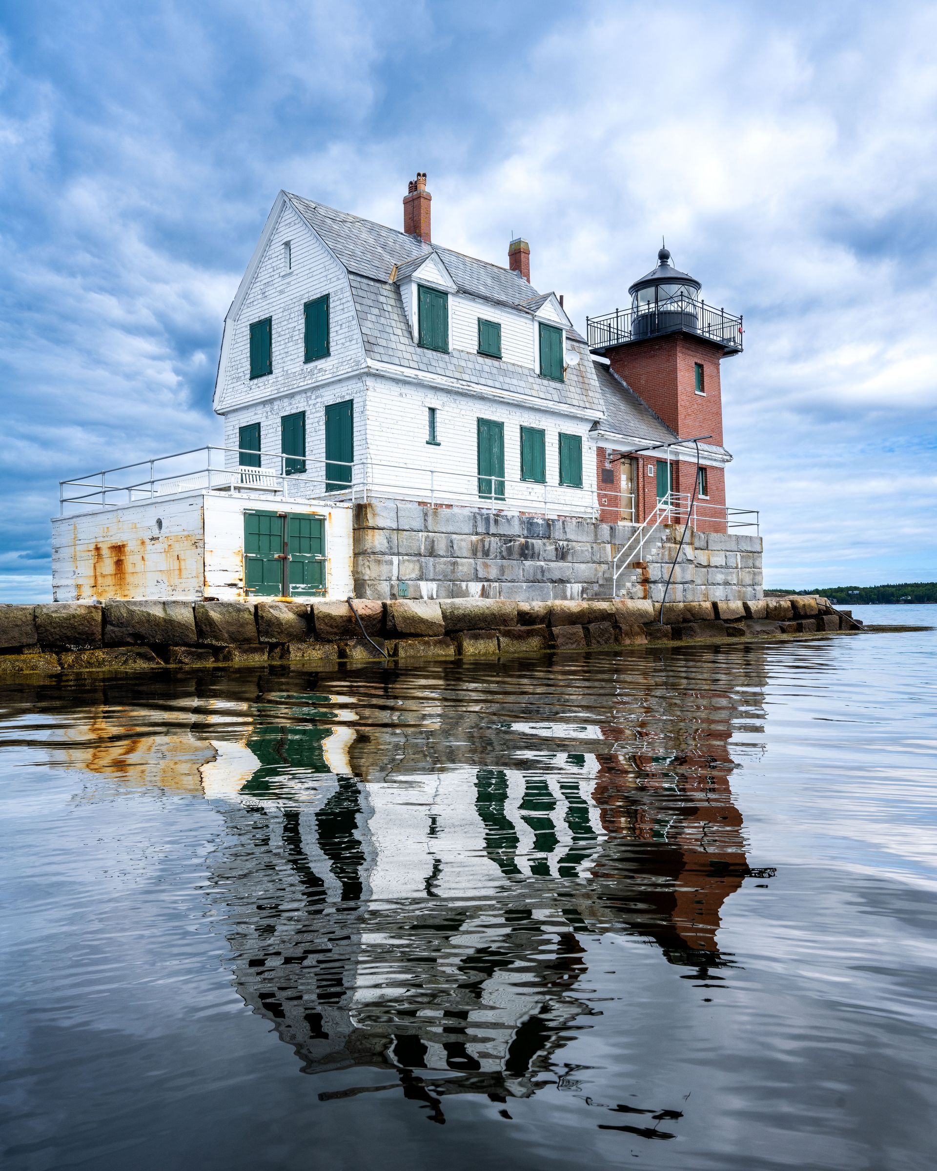 a lighthouse is sitting on top of a breakwater in the middle of a body of water . Rockland Breakwater Lighthouse, Talking Excitingly, Brad Burgess Photography
