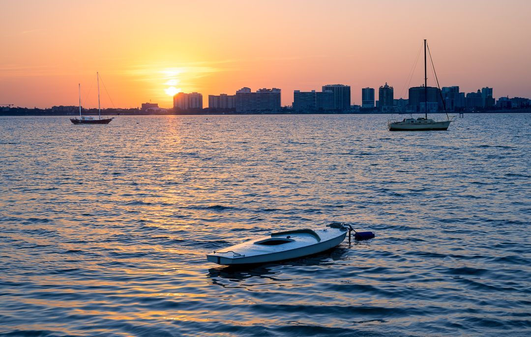 a boat is floating in Sarasota Bay at sunrise.  Sarasota Bay, Sarasota FL, Brad Burgess Photography, Talking Excitingly