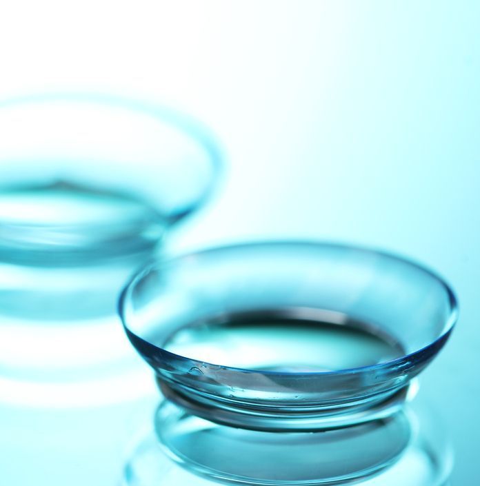 Pairs of contact lens and glasses on laying a table — Michael Chu Optometrist in Cairns North, QLD