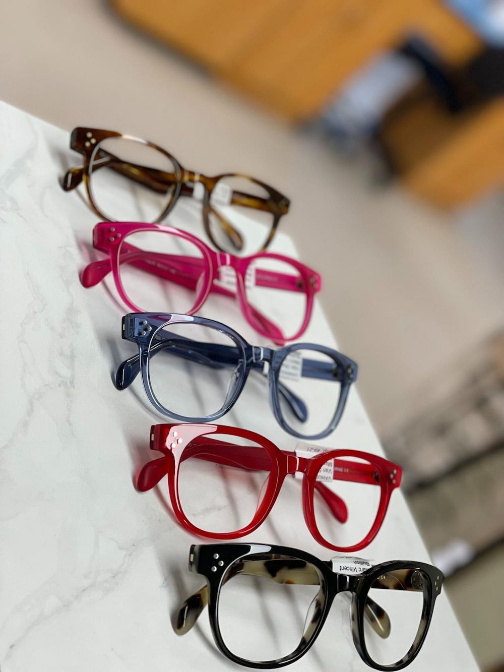 Several Pairs of Glasses Are Lined Up on a Table — Michael Chu Optometrist in Cairns North, QLD