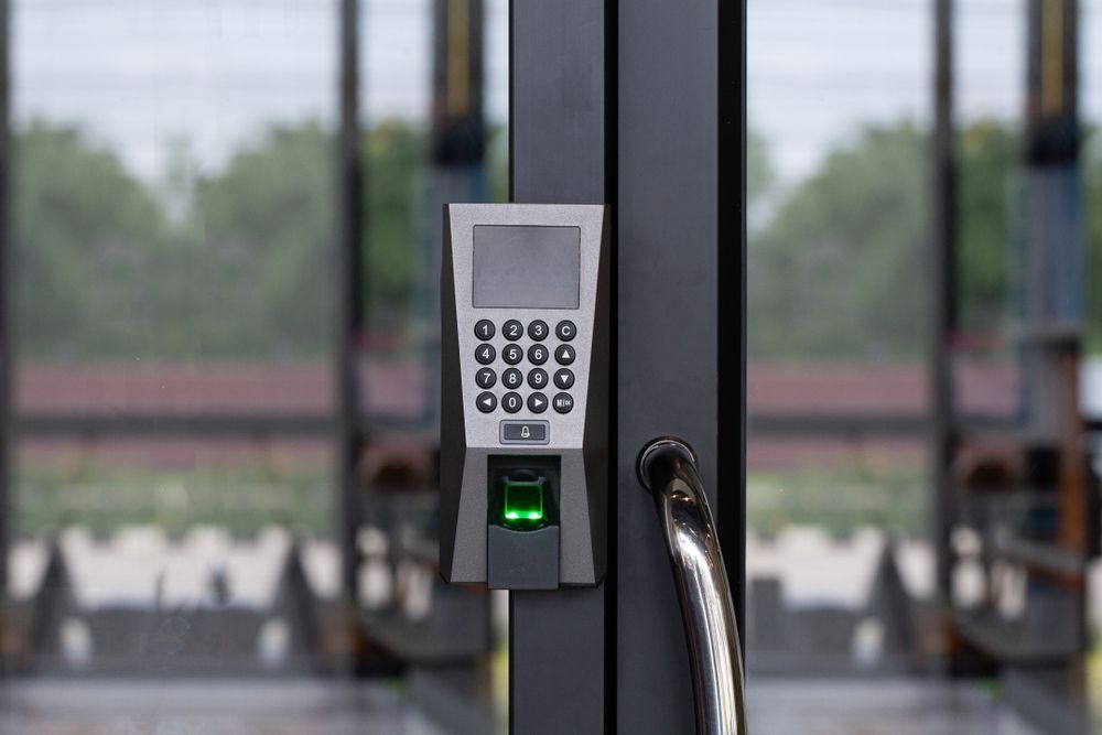 A close up of a fingerprint scanner on a glass door.