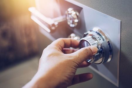A person is opening a safe with a key.