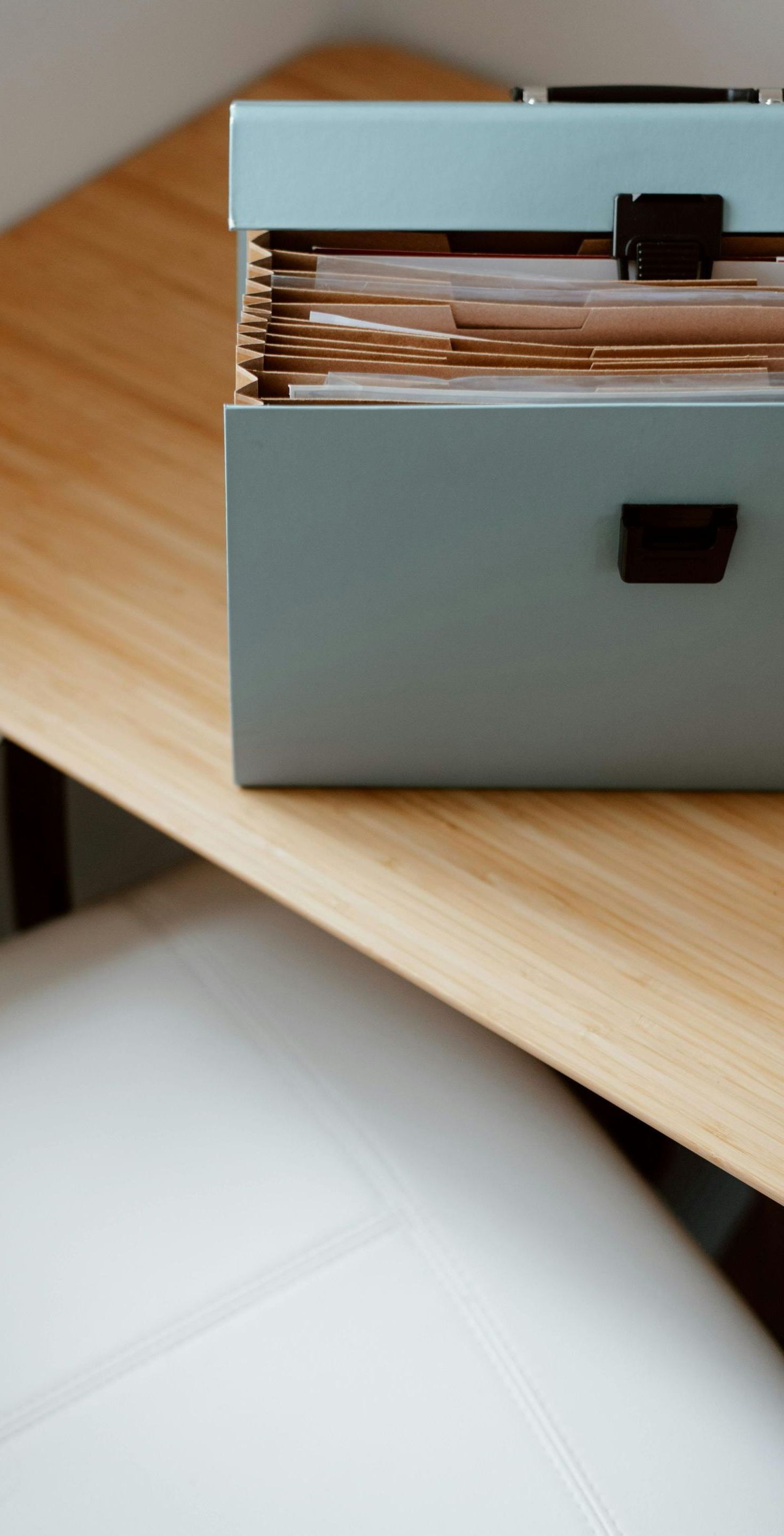 A box filled with papers is sitting on a wooden table.