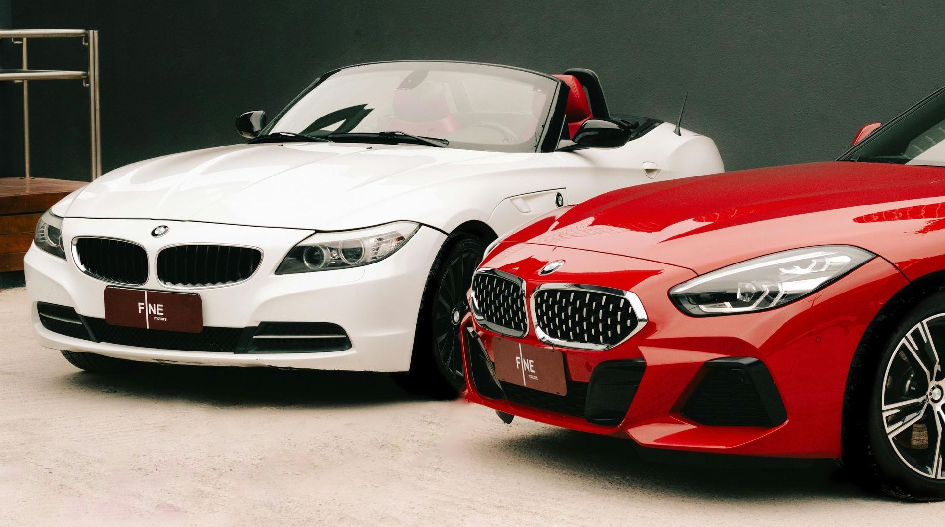 A red and a white sports car are parked next to each other.