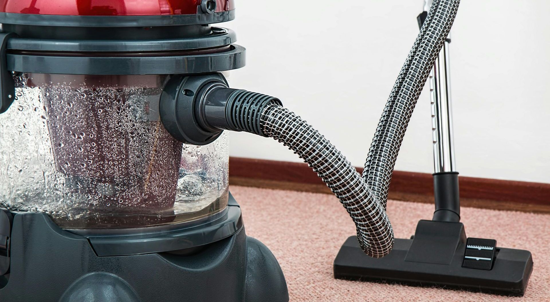 A vacuum cleaner is sitting on a carpet in a room.