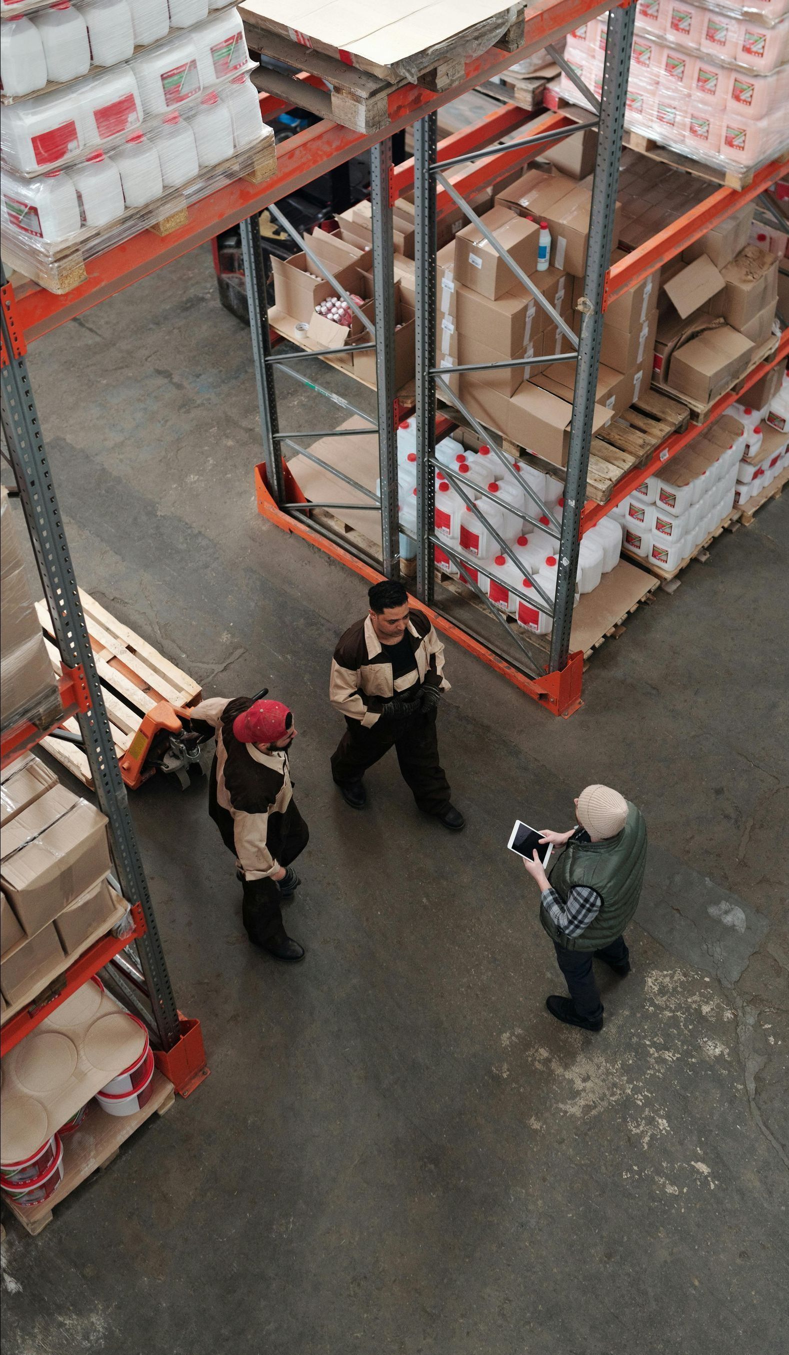 A group of people are standing in a warehouse talking to each other.