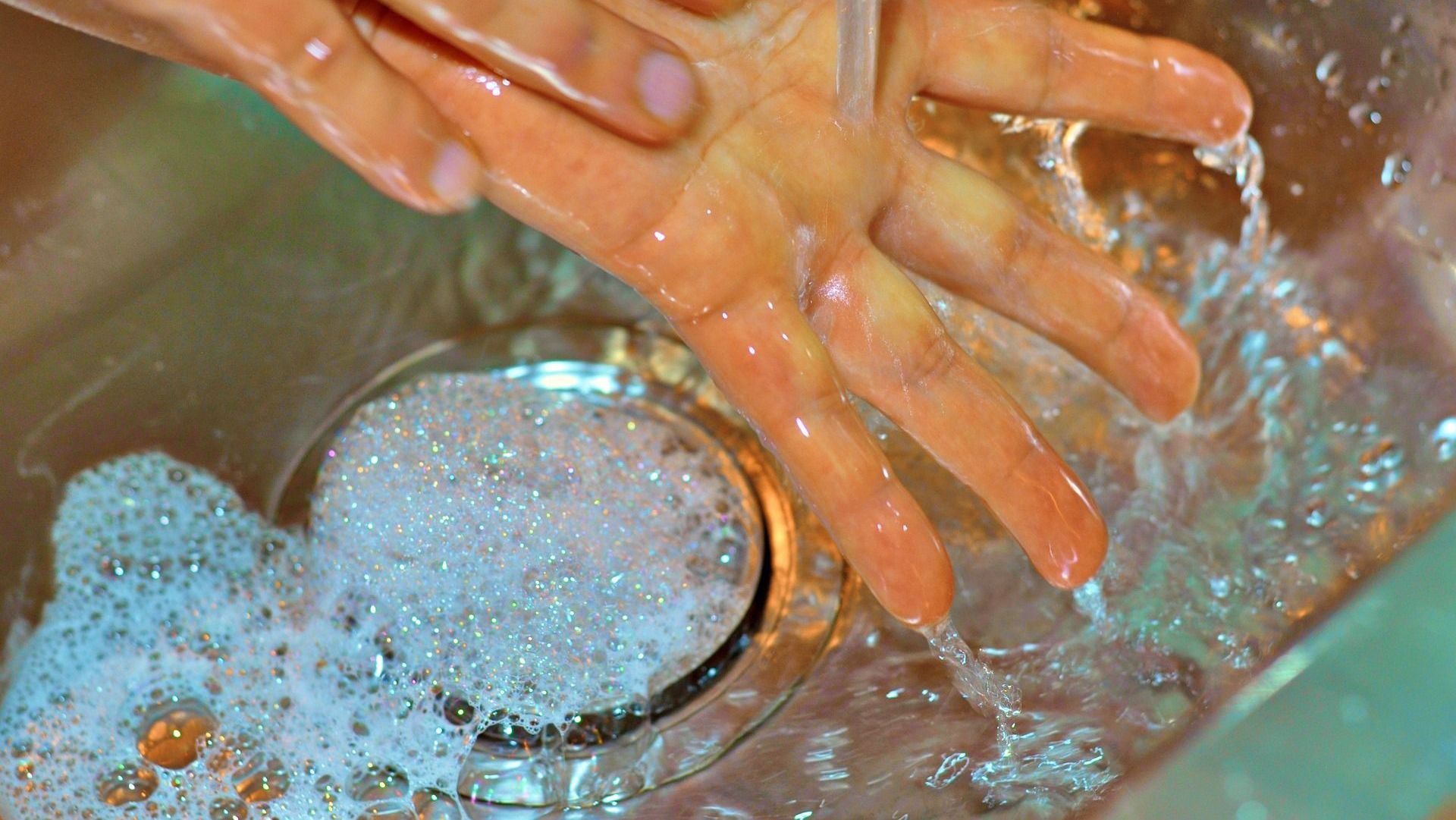 A person is washing their hands in a sink.