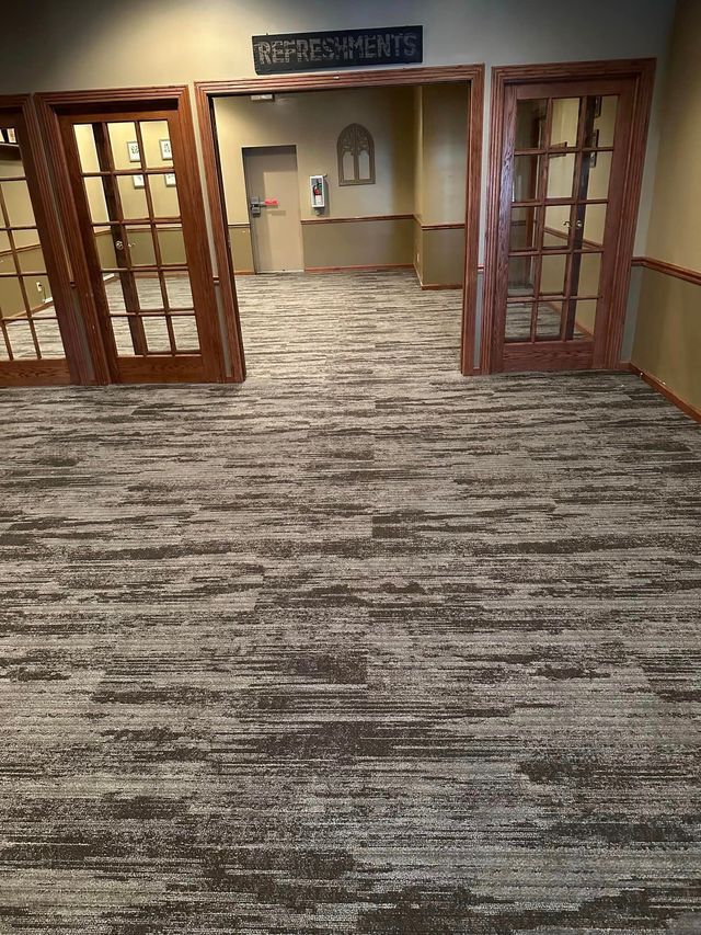 A room with a carpeted floor and a sign that says refreshments