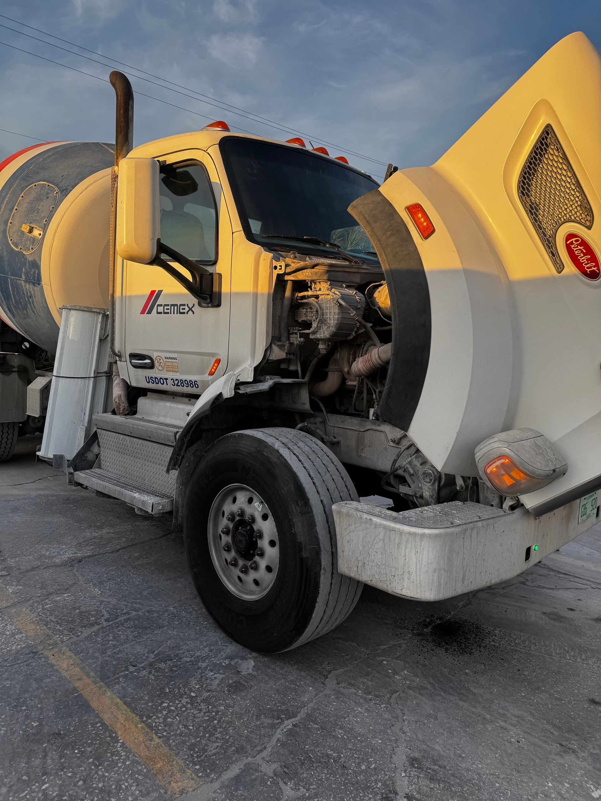 Windshield Replacement: Yellow and white cement mixer truck parked on a gravel lot