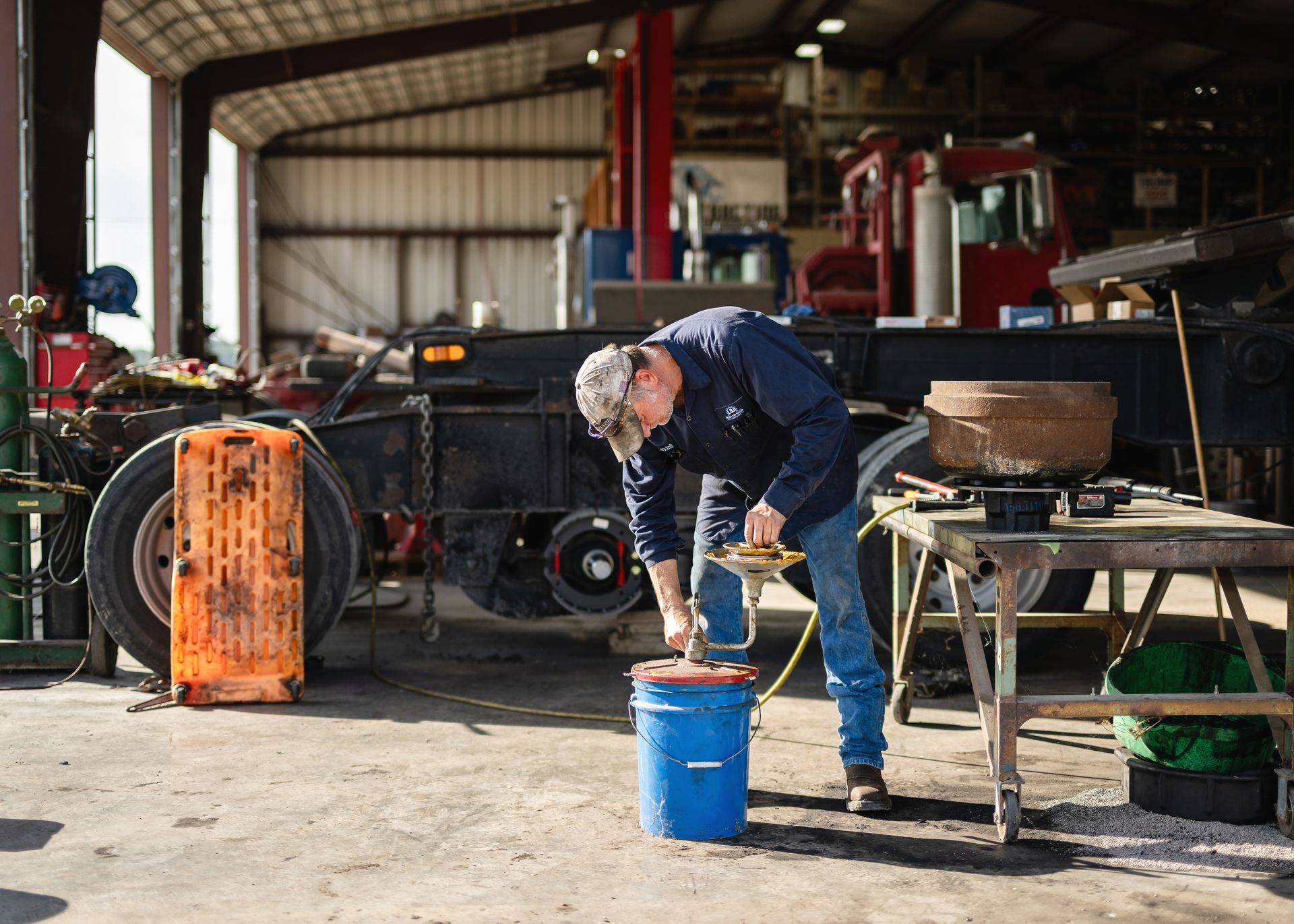 Welder in a protective mask using a torch, bright sparks flying in a dark workshop