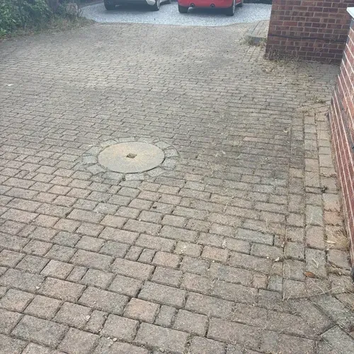 Weathered block paving driveway before professional cleaning
