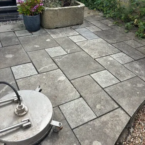 Black limestone patio with heavy weathering and organic staining before restoration