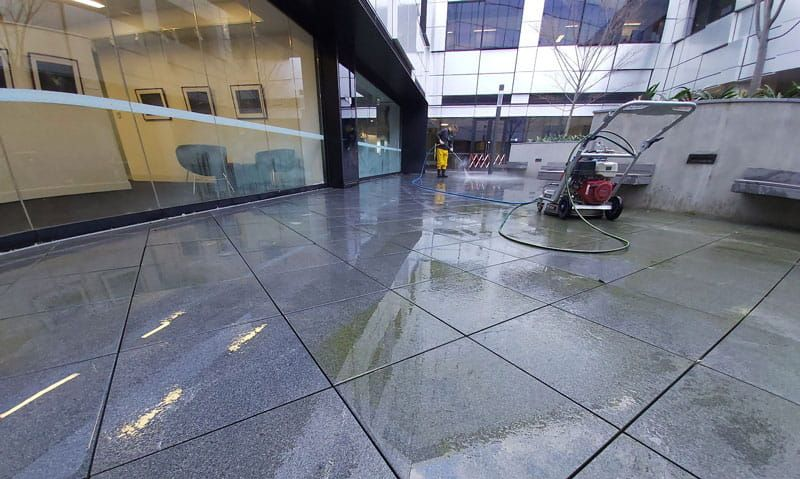 Pressure washing front entrance of office block in Hull city center.