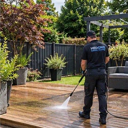 Professional pressure washing of timber decking in a garden