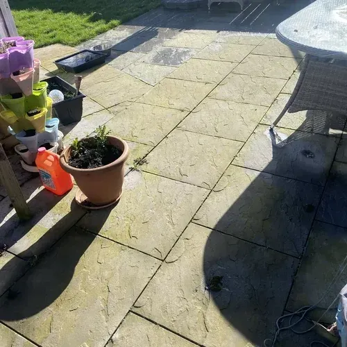 Garden flagstone patio with green algae and weathering before professional cleaning