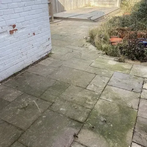 Indian sandstone patio with algae and weathering before professional cleaning
