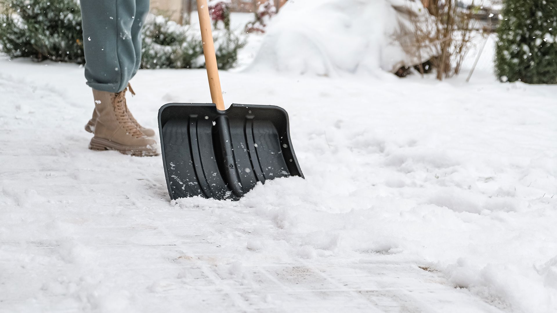 Man using snow shovel on driveway