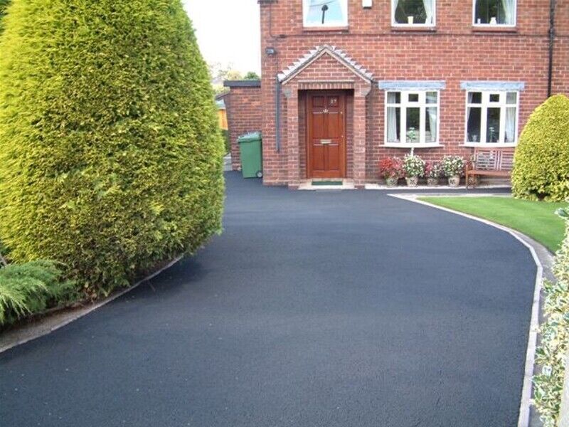 long tarmac driveway with red brick house. Tarmac restoration has been completed by Hedon Exterior cleaning in Hull