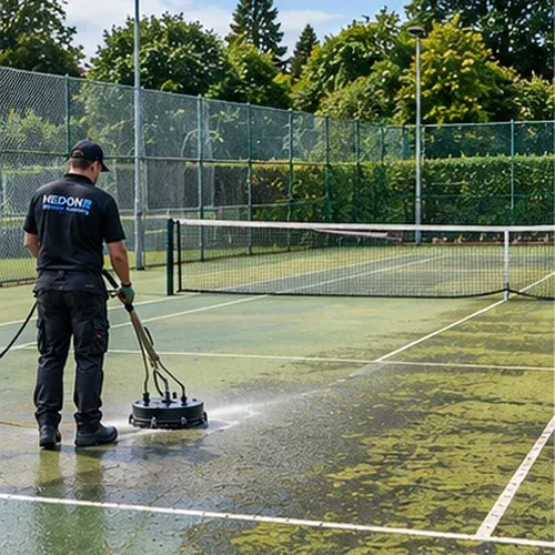 Professional pressure washing of an outdoor tennis court with organic growth