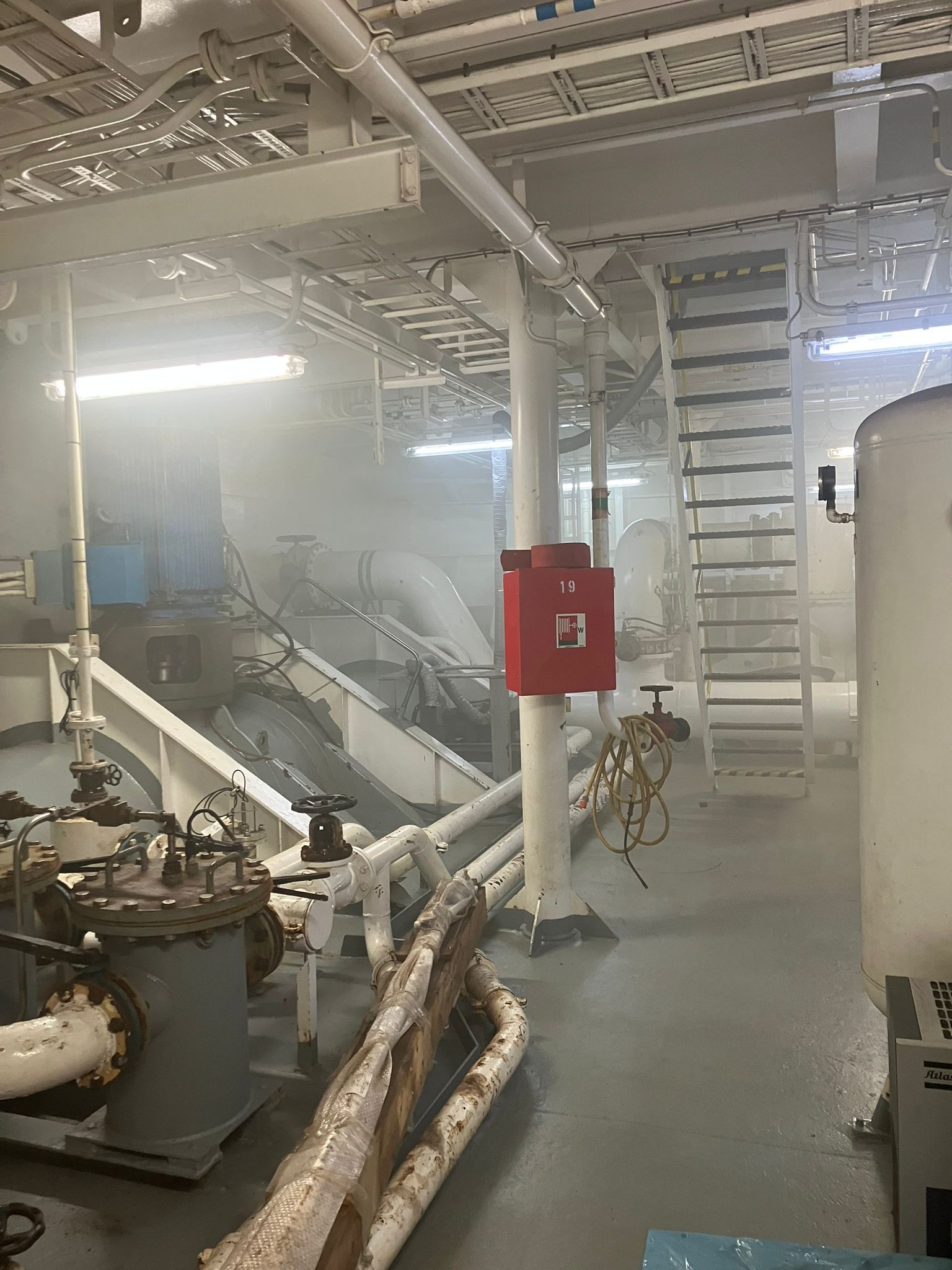 Interieur van de machinekamer van een schip, gevuld met rook. 