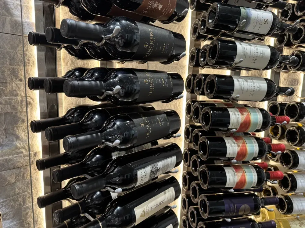 A vertical wine rack with several shelves filled with bottles of red wine.