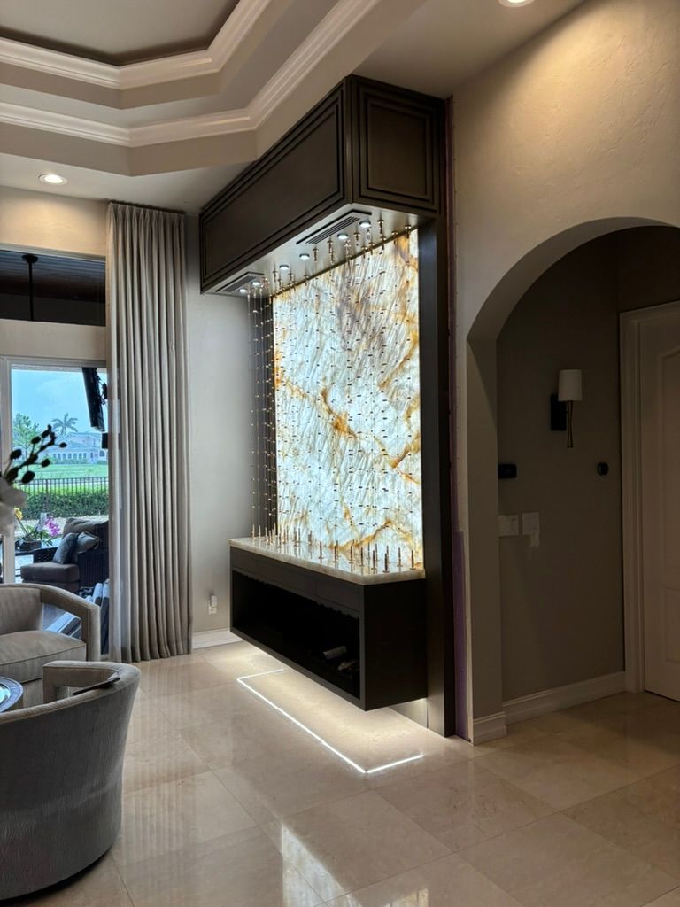 A modern interior featuring a backlit, glowing stone accent wall with a dark floating console and ambient floor lighting.