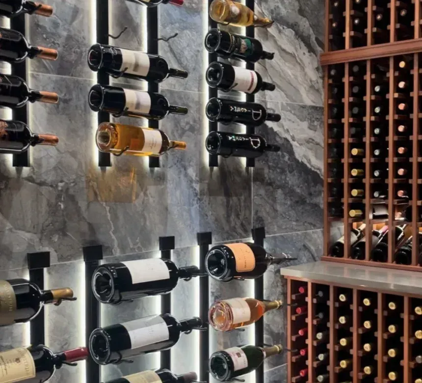 A wine cellar featuring wall-mounted bottle racks with integrated lighting and a traditional wooden grid wine rack.