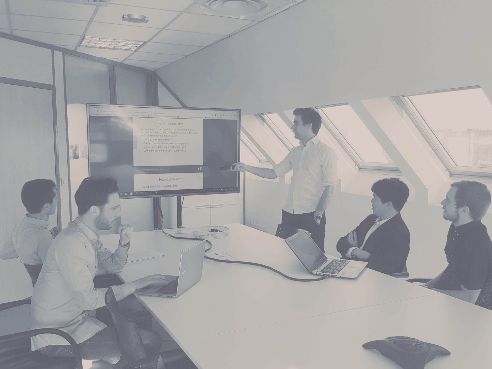A man is giving a presentation to a group of people in a conference room.