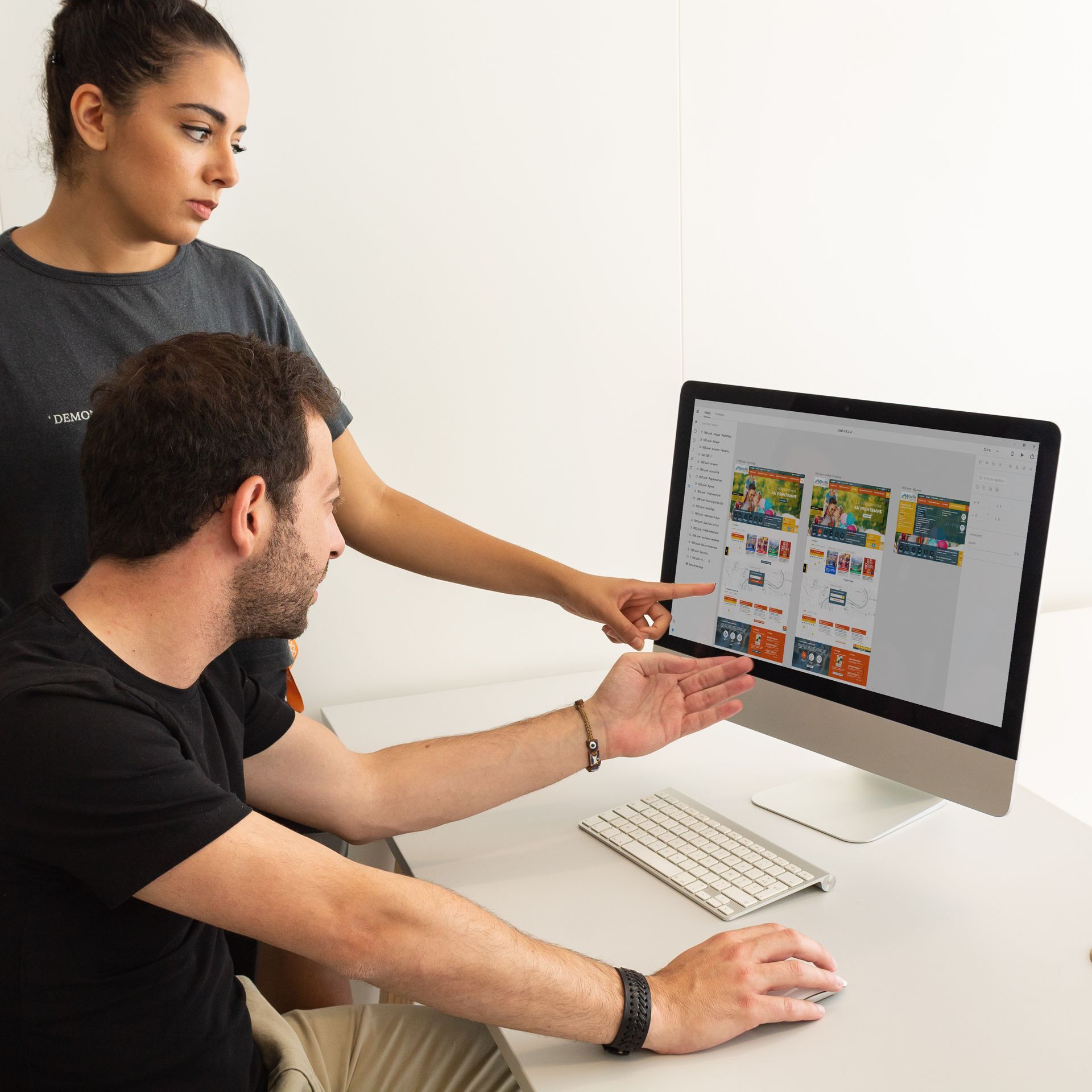 A man and a woman are looking at a computer screen.