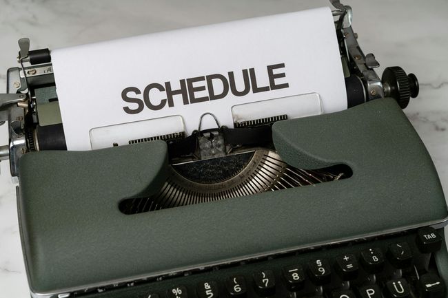 Typewriter printing the word “SCHEDULE” on paper