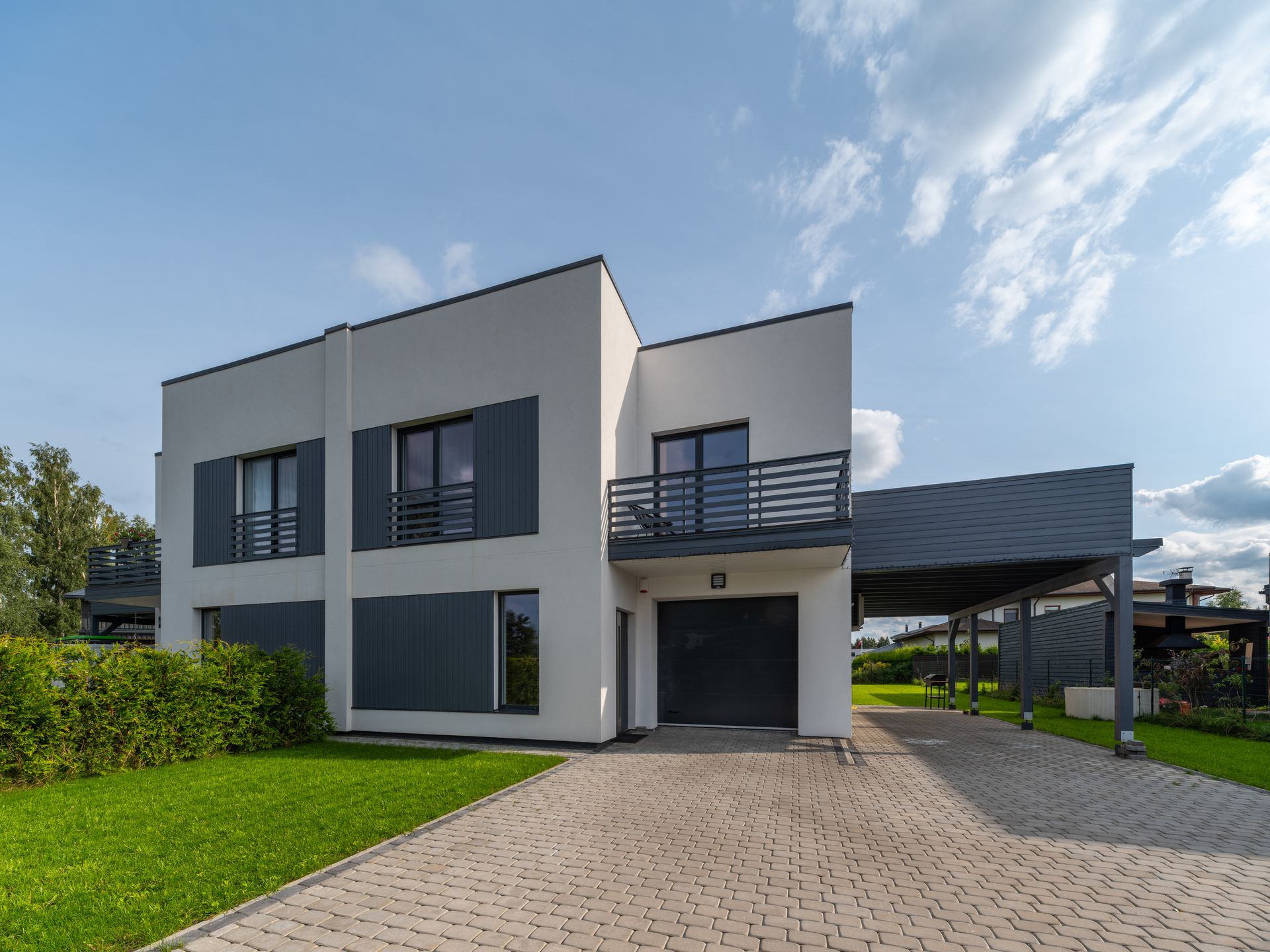 Une maison moderne avec un grand garage et une allée qui y mène.