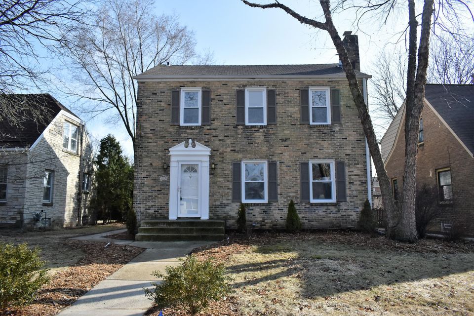 A large brick house with a white door and shutters
