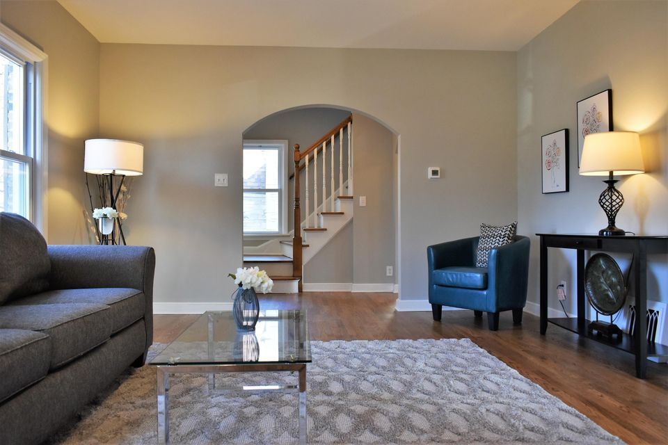 A living room with a couch a chair and a glass coffee table