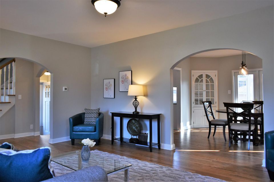 A living room with a couch a chair a table and a lamp