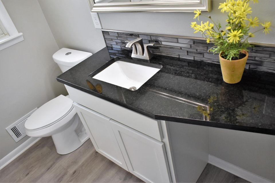 A bathroom with a toilet , sink , and mirror.