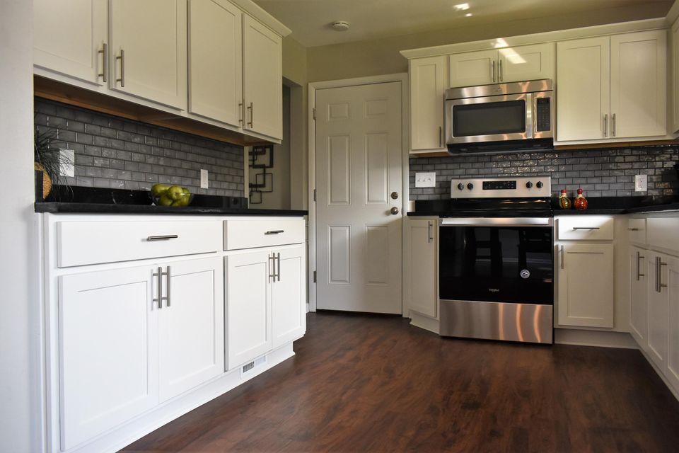 A kitchen with white cabinets and stainless steel appliances
