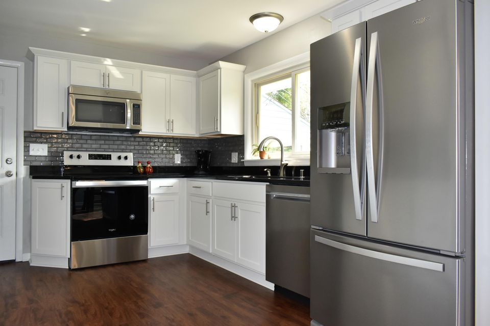 A kitchen with stainless steel appliances and white cabinets.