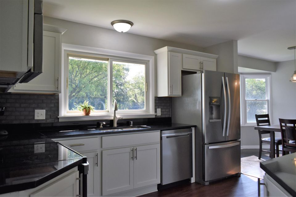 A kitchen with stainless steel appliances and white cabinets