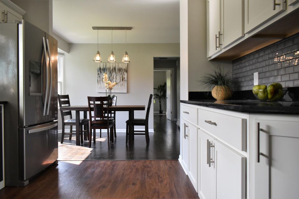 A kitchen with a table and chairs and a refrigerator