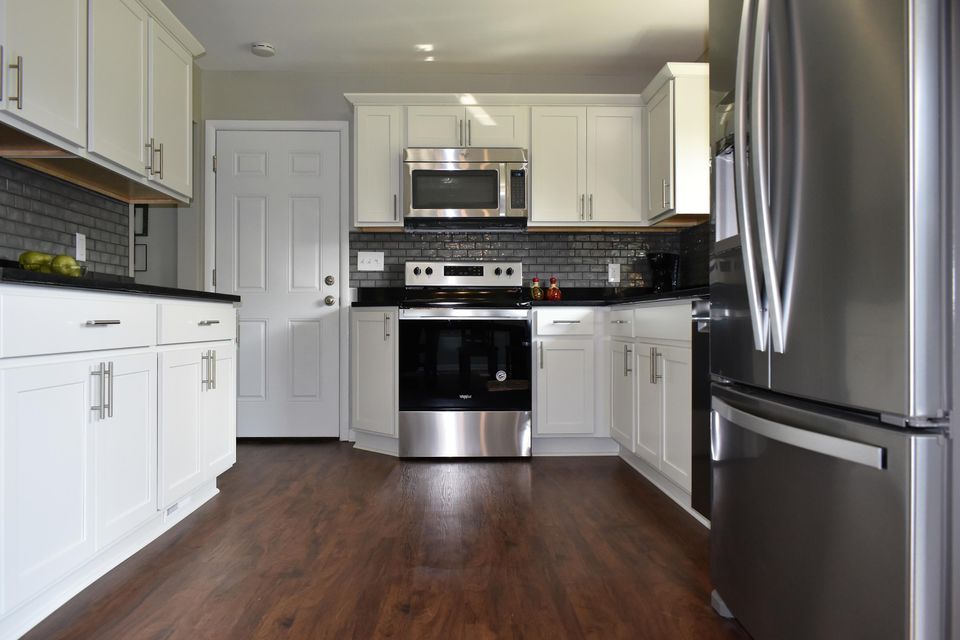 A kitchen with stainless steel appliances and white cabinets