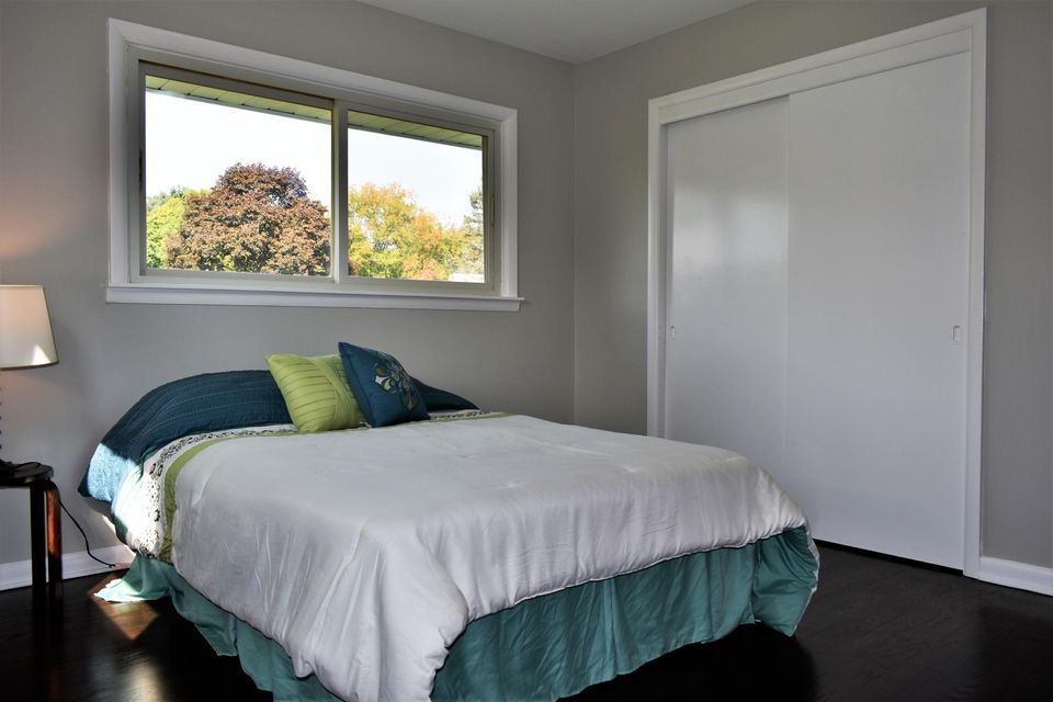 A bedroom with a bed , window and closet.