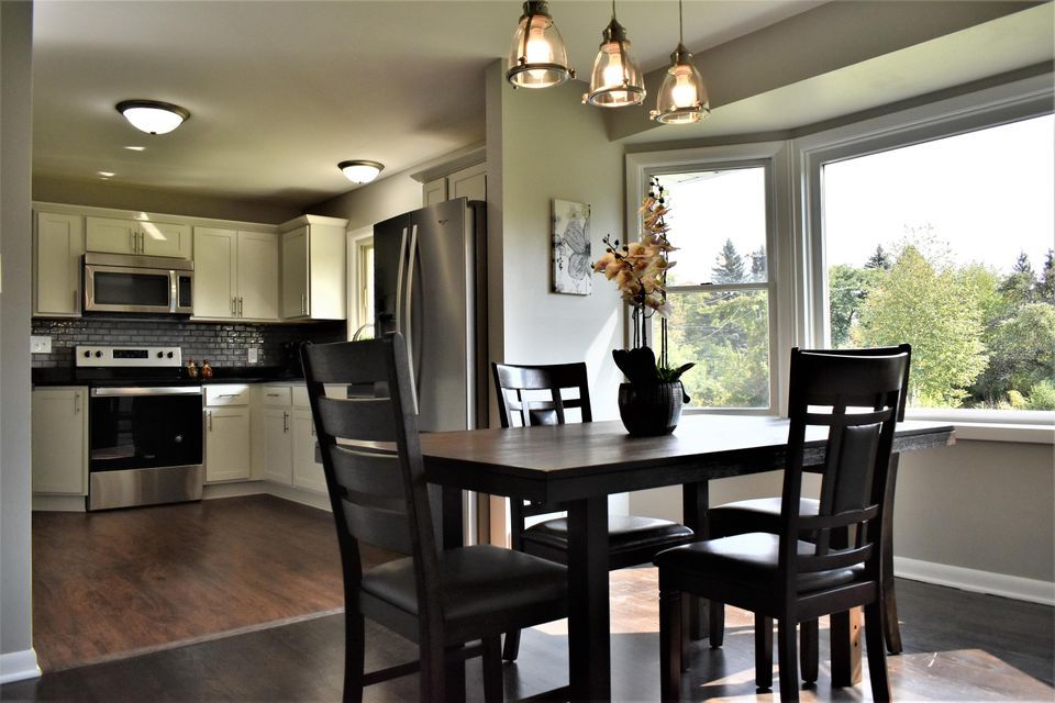 A kitchen with a table and chairs and a large window